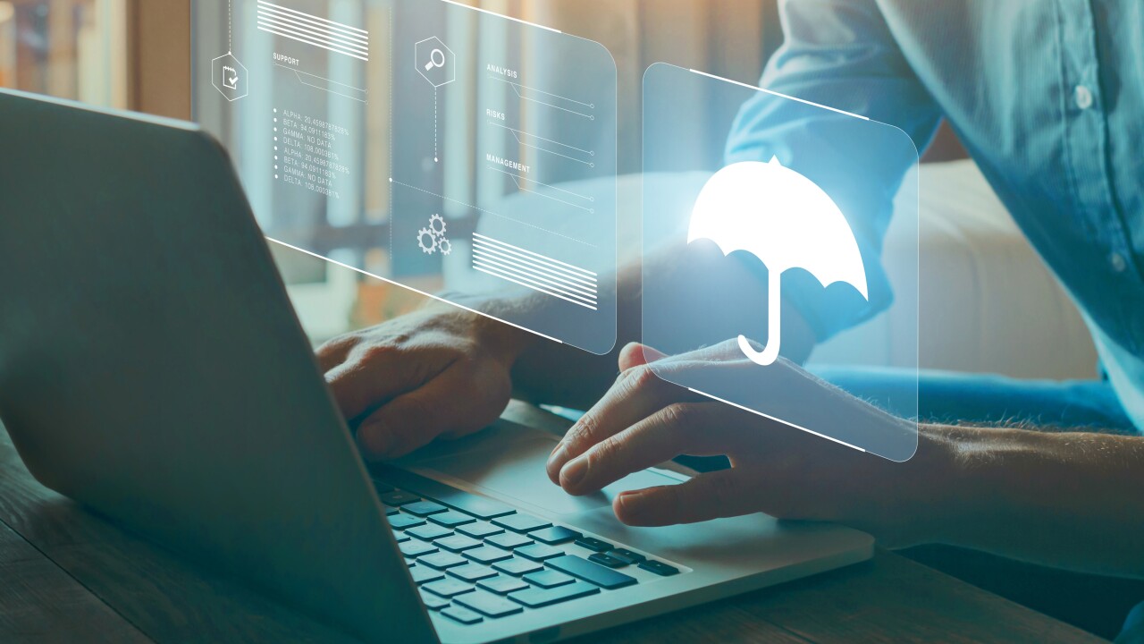 A person using a laptop with a holographic images including an umbrella.