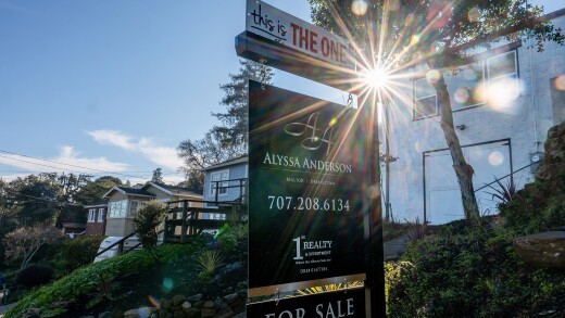 A picture of a for-sale sign outside a house.