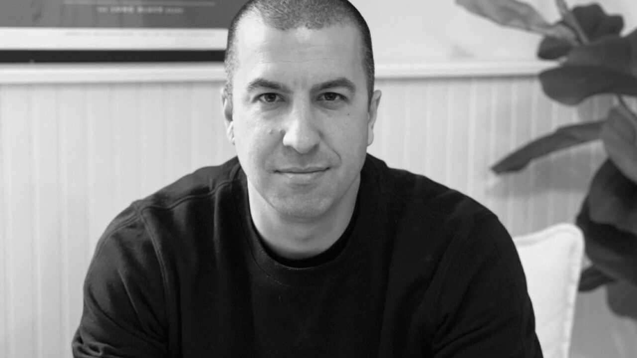 black and white close-up photo of Dakota CEO Ryan Bozarth wearing a black crewneck with a plant behind his left shoulder