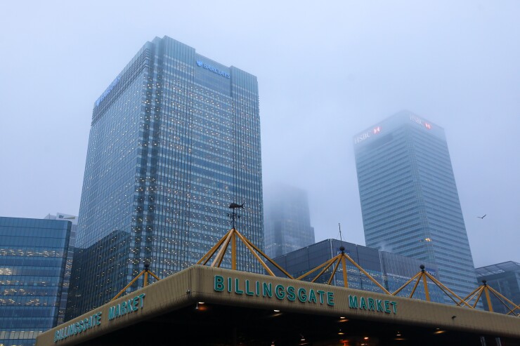 Billingsgate Fish Market stands in front of the Barclays and the HSBC headquarter buildings in the Canary Wharf financial, business and shopping district in London.