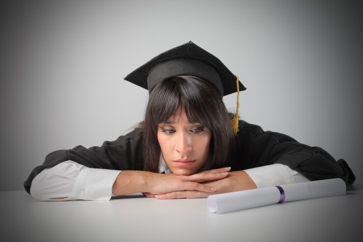 Woman college graduate looking at diploma sad