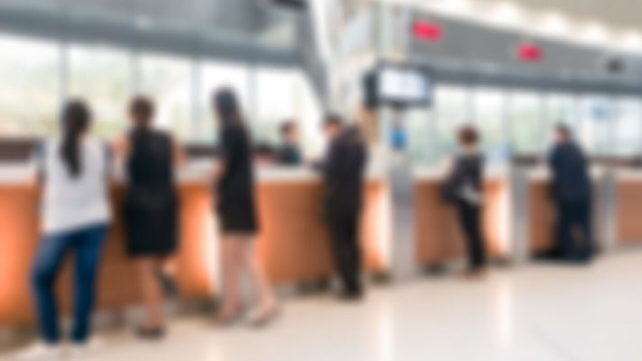 Customers lined up at a bank counter.