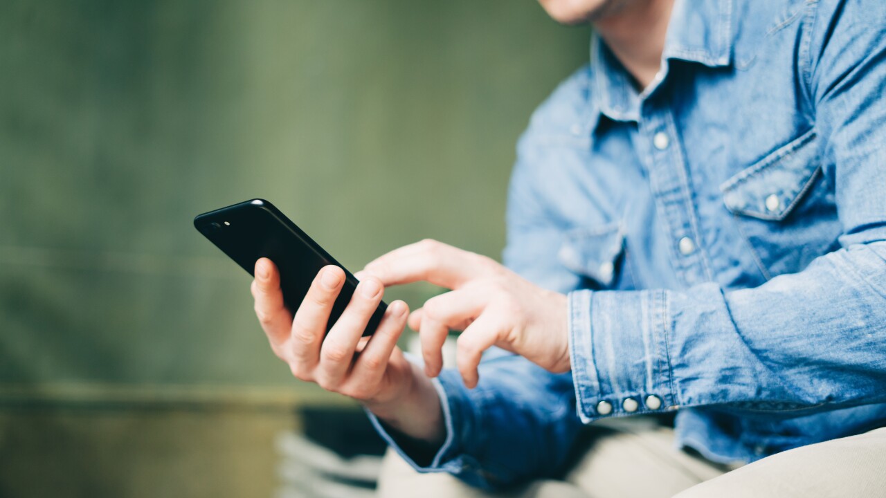 A man holds a black smartphone.