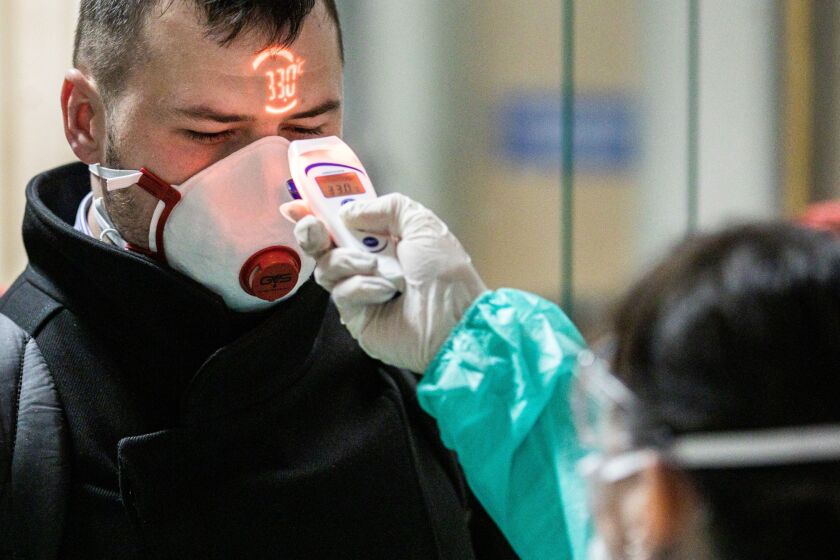 An airline passenger arriving in Italy is screened for coronavirus exposure