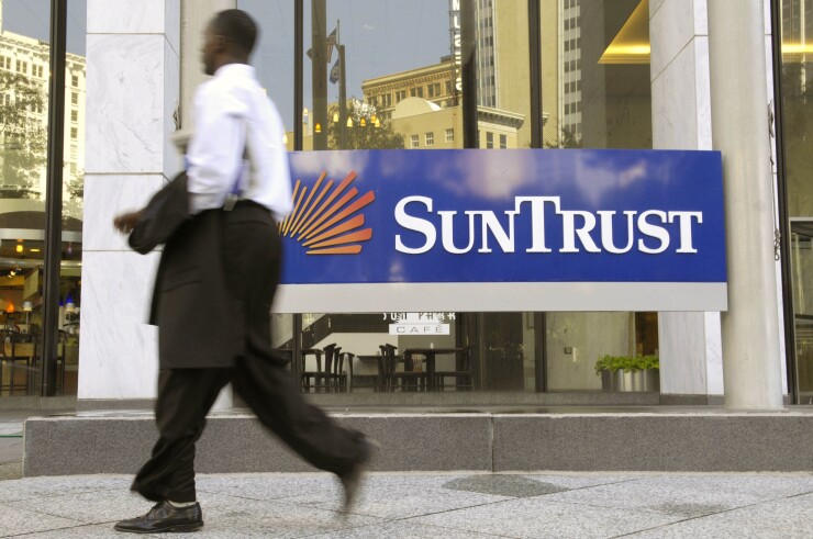 A pedestrian passes by the SunTrust Bank headquarters in Atlanta, Georgia.