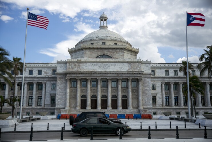 American and Puerto Rican flags fly outside the Capitol of Puerto Rico building in San Juan, Puerto Rico