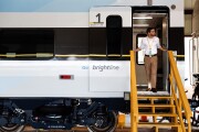 An All Aboard Florida representative looks out of a Brightline passenger train door during a media tour in West Palm Beach, Florida, U.S., on Wednesday, Jan. 11, 2017.