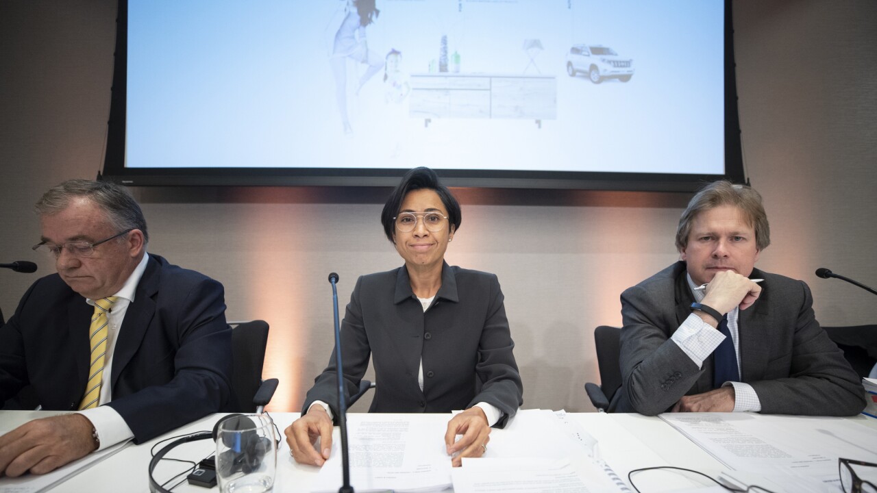 Heather Sonn, chairman of Steinhoff International Holdings NV, center, sits between Danie van der Merwe, acting chief executive officer of Steinhoff International Holdings NV, left, and Ewoud van Gellicum, company secretary of Steinhoff International Holdings NV, during the company's annual general meeting in Amsterdam.