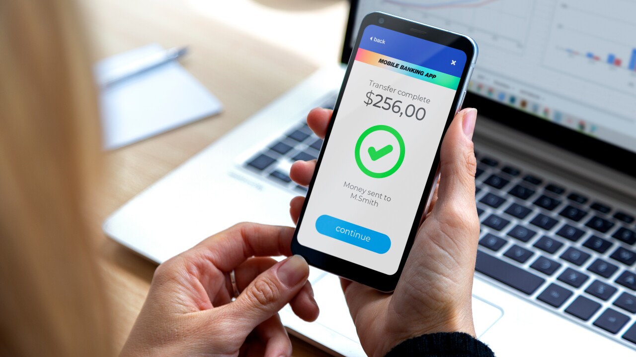 Person holding cell phone with money amount and check symbol