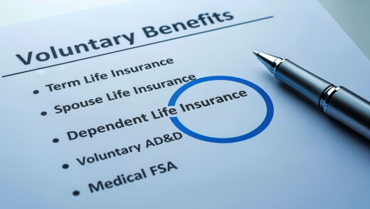 Voluntary Benefits Form with Pen Highlighting Spouse Life Insurance Option for Employee Enrollment.