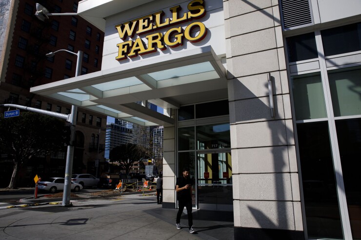 Pedestrians walk past a Wells Fargo bank branch in Los Angeles.