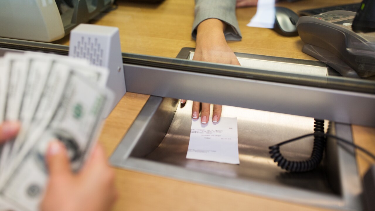 bank clerk giving receipt to customer with money