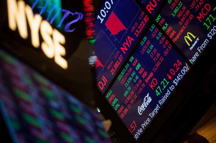 A monitor displays stock market information on the floor of the New York Stock Exchange.