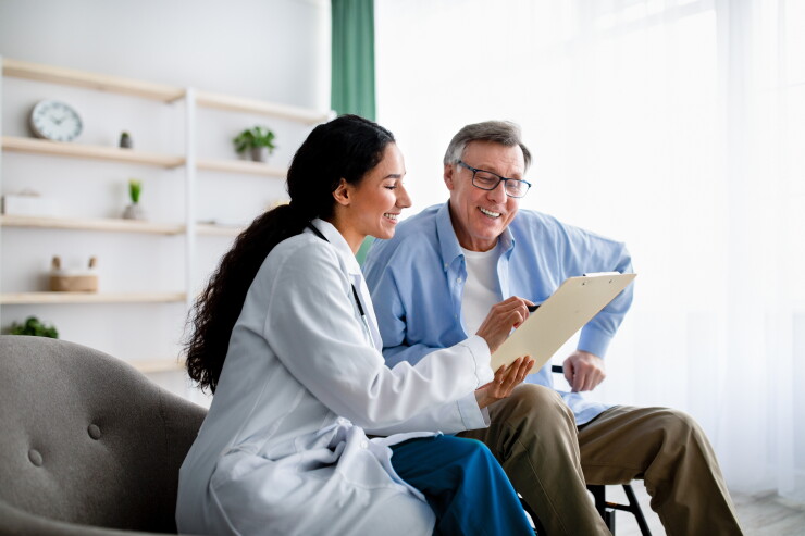Man sitting with female doctor going over medical information