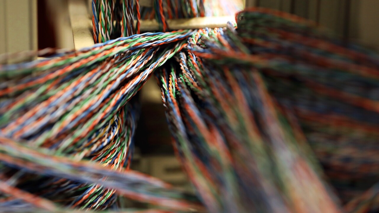 Twisted copper wiring sits in an electrical unit inside a communications room at an office in London.
