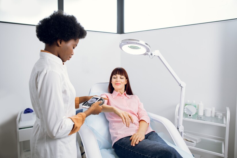Patient receiving medical test with medical professional standing next to exam table