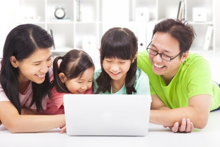 Family with children looking at laptop