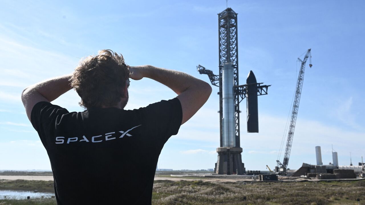 Man in a SpaceX t-shirt looking at a rocket launch