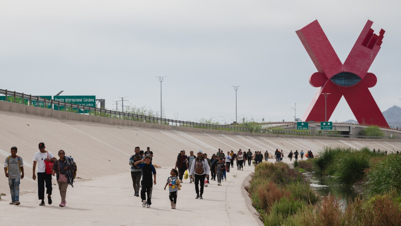 A picture of migrants walking along the Mexico-U.S. border in Ciudad Juarez, Mexico.