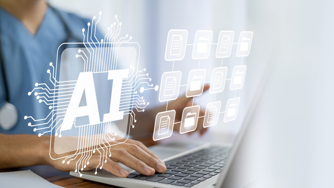 A health professional working at a laptop.