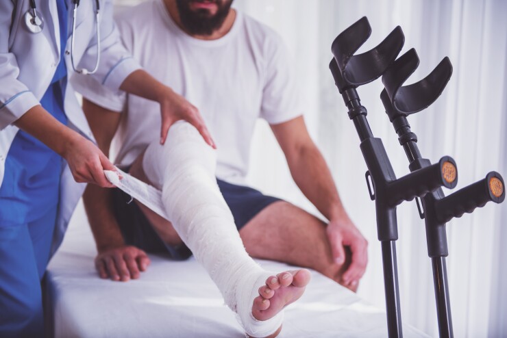 Man getting leg wrapped in cast by doctor