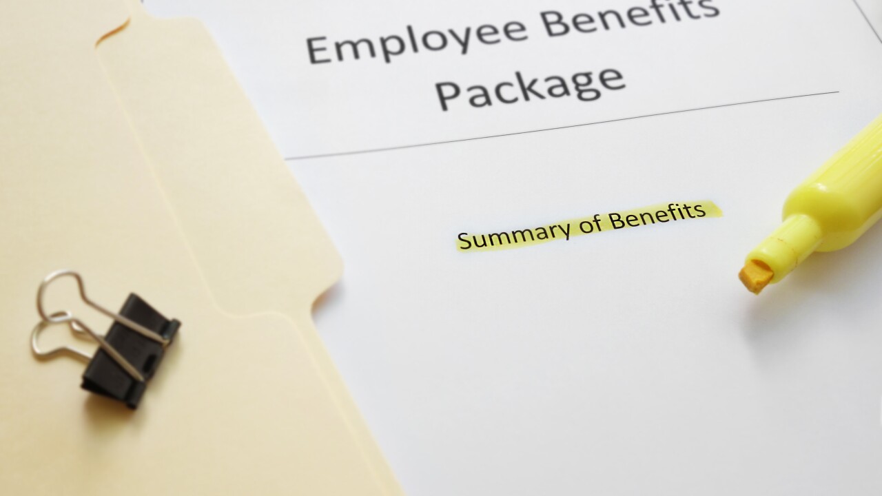 A folder rests on a table next to a paper titled, "Employee Benefits Package."