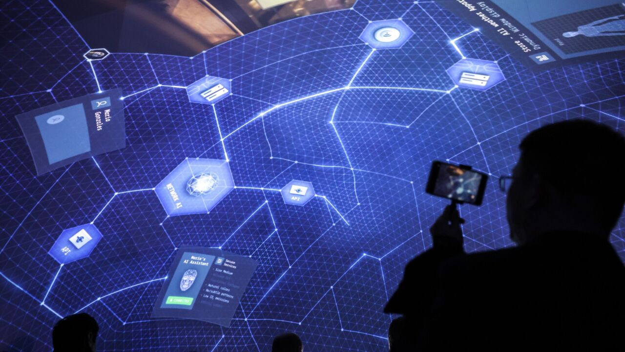 An attendee films a rooftop artificial intelligence (AI) presentation on a smartphone at the Ericsson AB stand on the opening day of the Mobile World Congress at the Fira de Barcelona venue in Barcelona, Spain, on Monday, Feb. 27, 2023. The annual flagship mobile industry and technology event runs from Feb. 27 to March 2. Photographer: Angel Garcia/Bloomberg