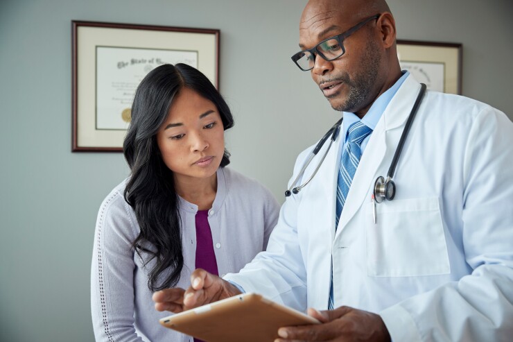 Woman leaning in to talk with doctor about medical information