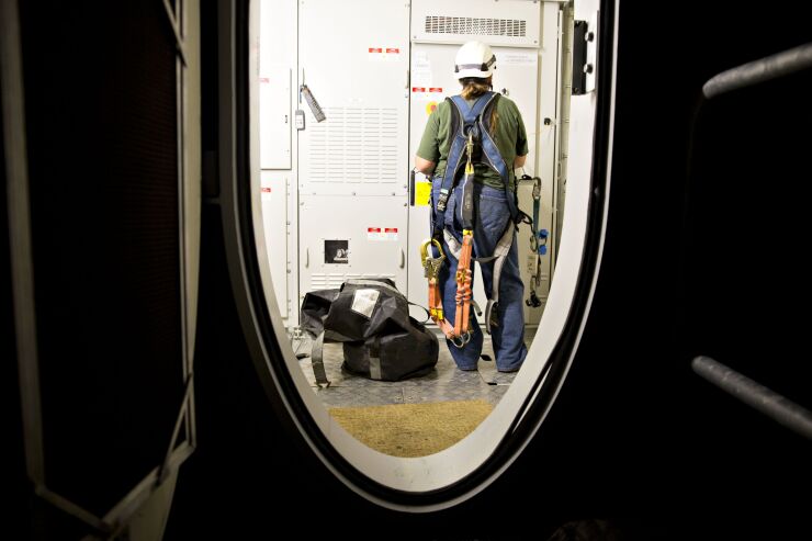 A technician works on a General Electric Co. wind turbine owned by Rural Electric Cooperative Inc. in Greenfield, Iowa, U.S., on Wednesday, Sept. 14, 2016. 