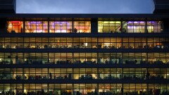 Electric lights illuminate office workers inside PwC's building in Dublin