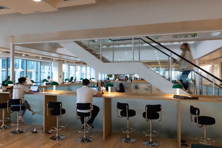 Office workers at bar seats in a WeWork co-working office space in the Waterloo district in London, U.K. on Monday, Aug. 2, 2021. A survey this month showed that just 17% of London’s white-collar workers want a full-time return, and many said it’d take a pay rise to get them back five days a week. Photographer: Jason Alden/Bloomberg