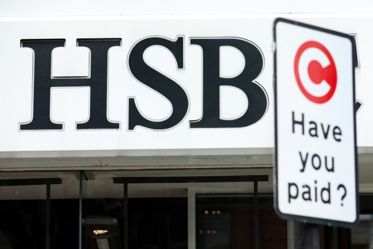 A sign for the London Congestion Charge stands outside a HSBC bank branch in London.