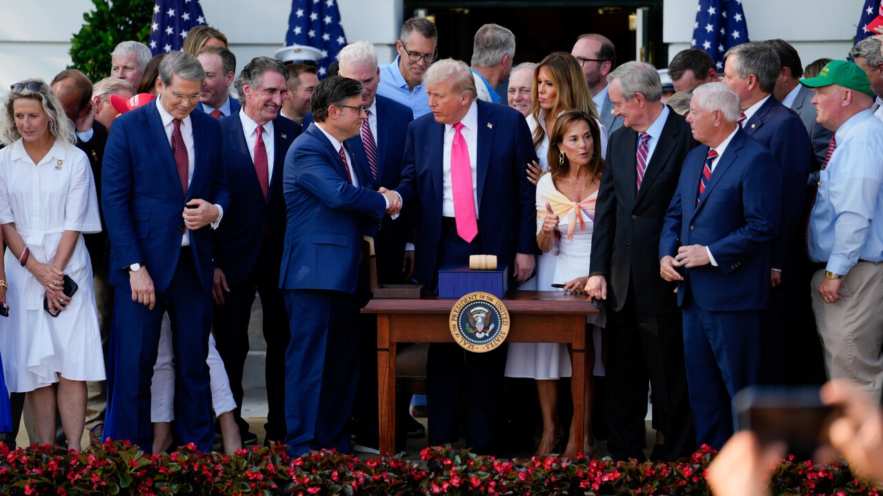 US President Donald Trump and US House Speaker Mike Johnson shake hands after signing the One Big Beautiful Bill Act