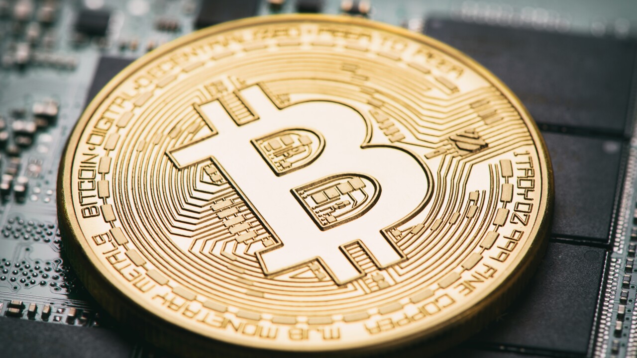 Golden coin imprinted with a Bitcoin logo.