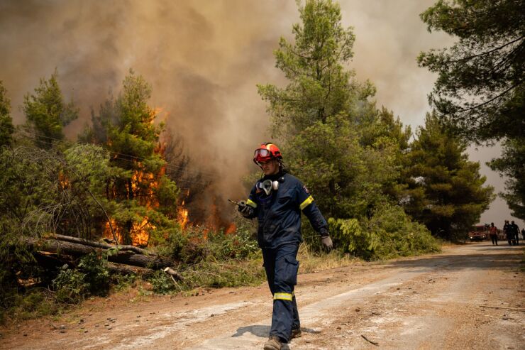 A firefighter walks past a forest wildfire near the village of Avgaria, on Evia island, Greece, on Aug. 10, 2021.