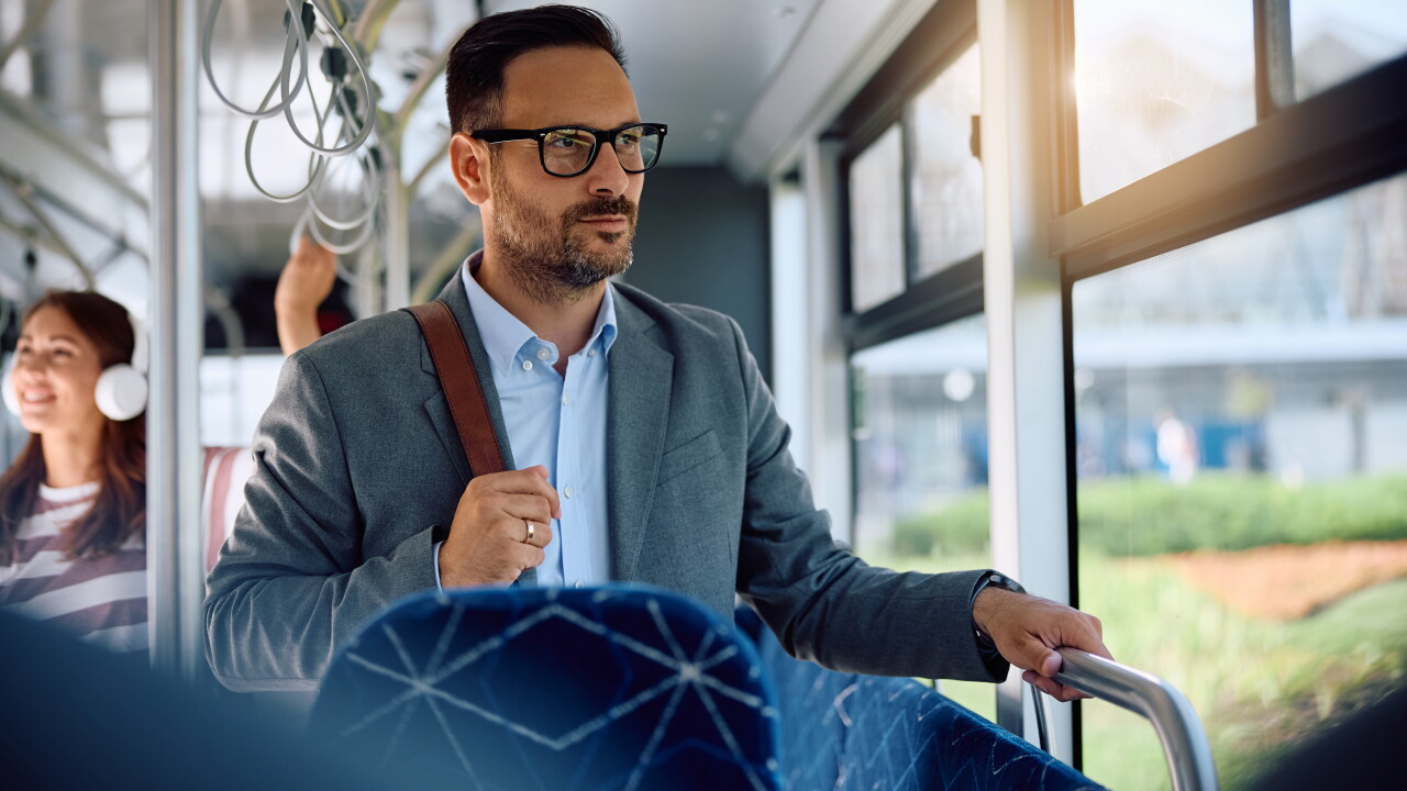 Man commuting to work with bag on bus