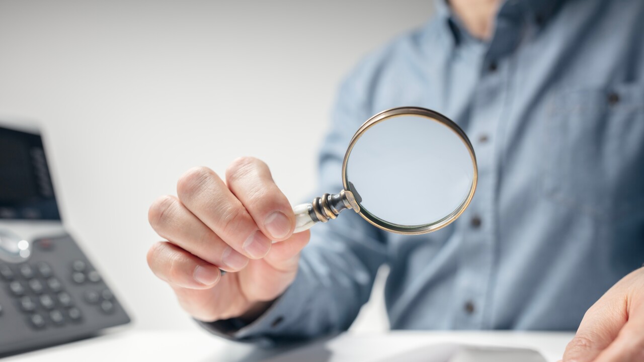 Man with magnifying glass reading documents or legal contract