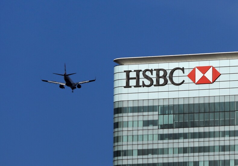 An airplane passing the offices of HSBC in the Canary Wharf district in London.