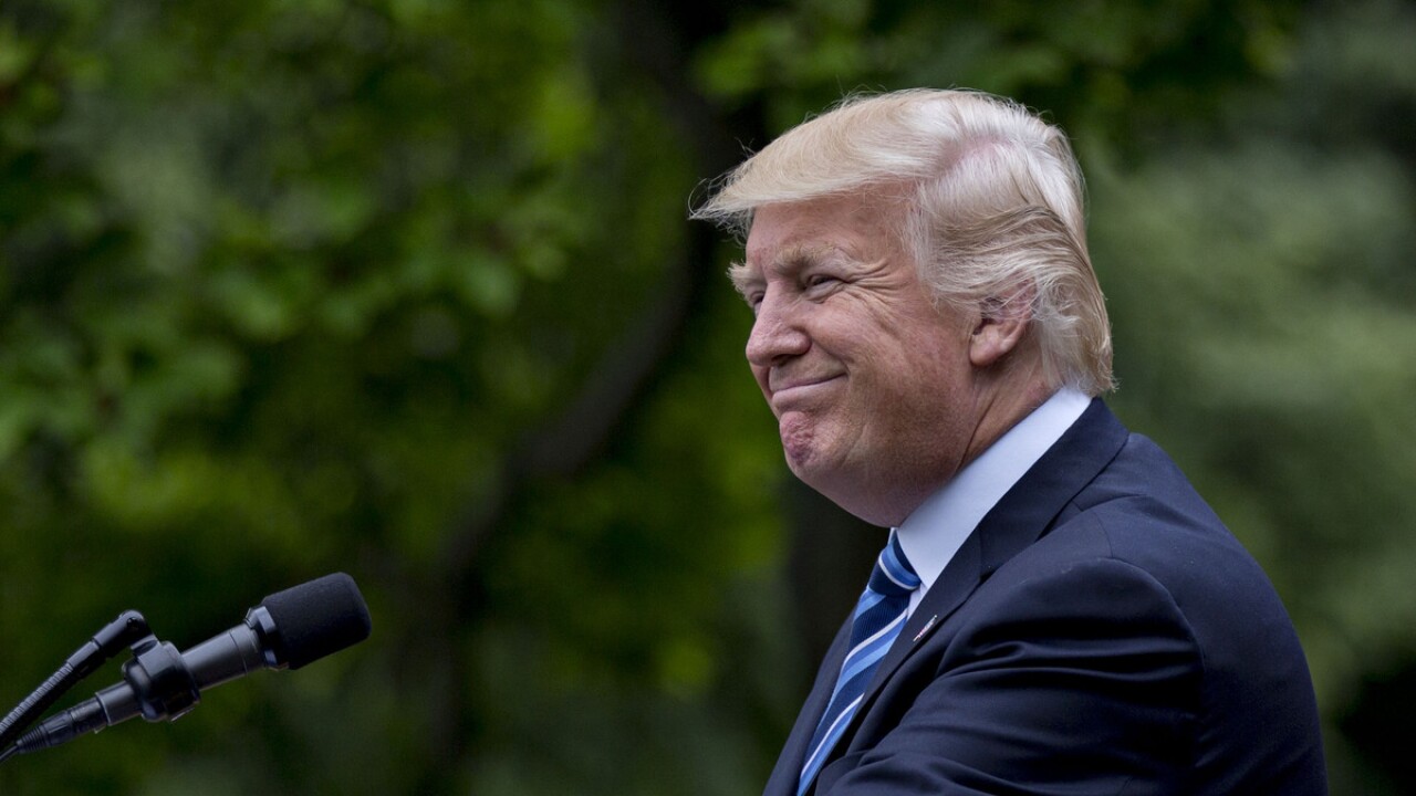 Donald Trump smiles while speaking during a press conference in the Rose Garden of the White House