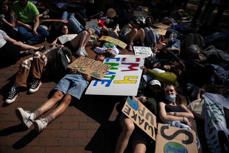 Demonstrators with Fridays for our Future perform a "die in" outside the White House on Earth Day to demand immediate action on climate change in Washington, D.C., U.S., on Friday, April 22, 2022. President Biden today signed an executive order designed to safeguard old-growth forests as the White House has faced criticism from environmental activists over the inability to provide significant funding for his climate agenda. Photographer: Graeme Sloan/Bloomberg