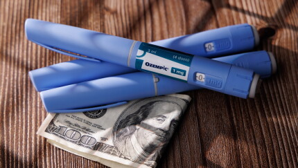 GLP-1 medication with money underneath; expensive