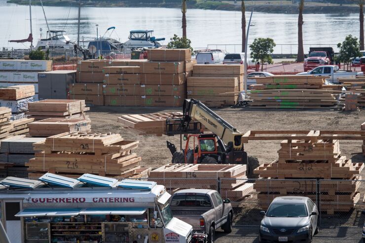 A worker operates machinery to move prefabricated frames in a lot that is designated for affordable housing at the Brooklyn Basin in Oakland, California, U.S., on Tuesday, Nov. 12, 2019.