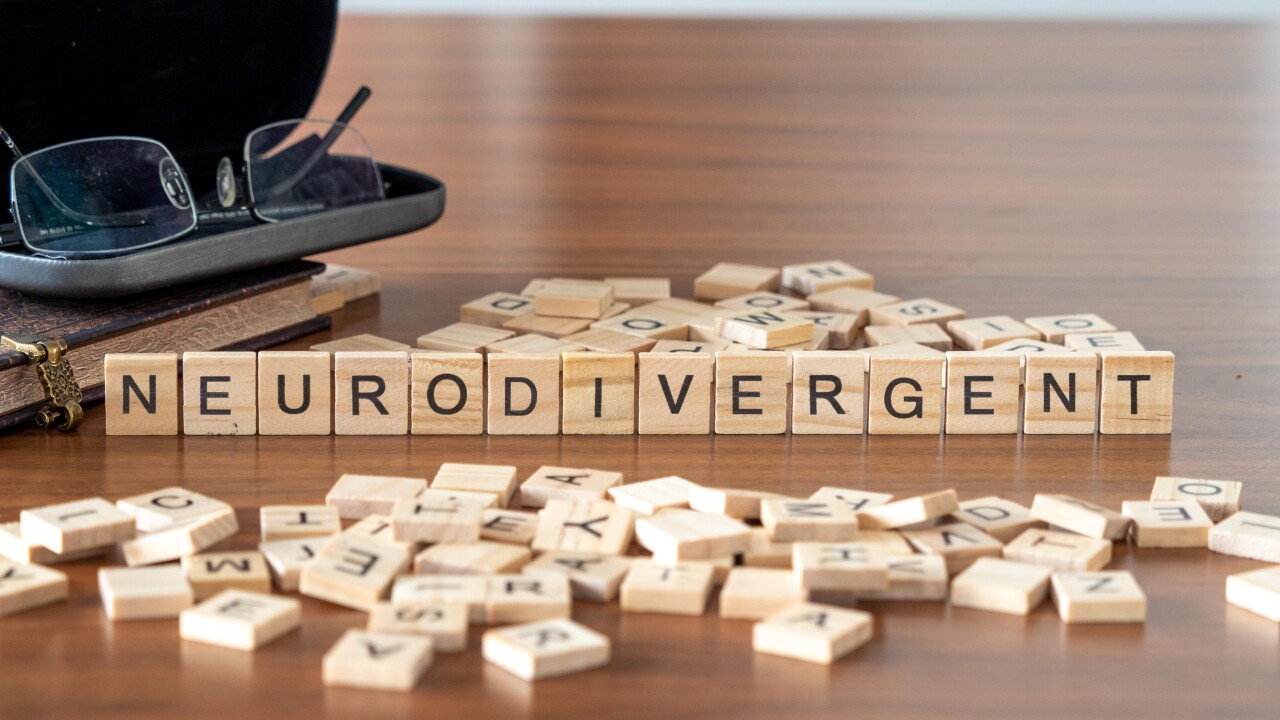 neurodivergent word or concept represented by wooden letter tiles on a wooden table with glasses and a book