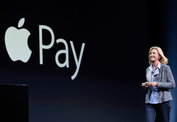 Apple VP Jennifer Bailey walks past Apple Pay logo for speech.