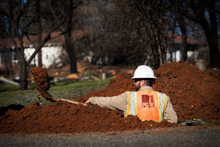 A Pacific Gas & Electric Co. employee digs a trench to locate gas lines in Paradise, California, U.S., on Tuesday, Jan. 22, 2019.