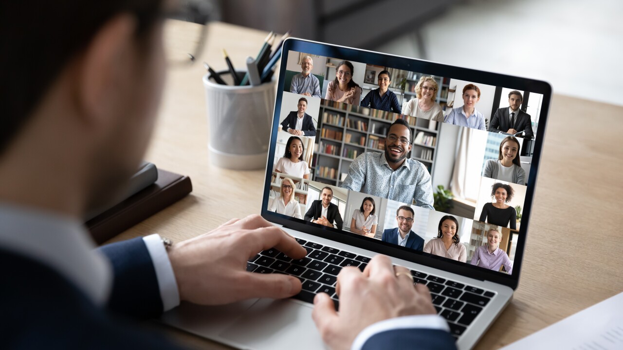 Businessman talking to team of colleagues on laptop online video conference