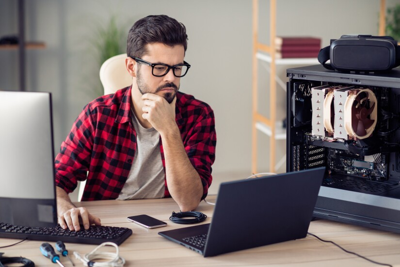 Man working on laptop buffalo plaid shirt glasses