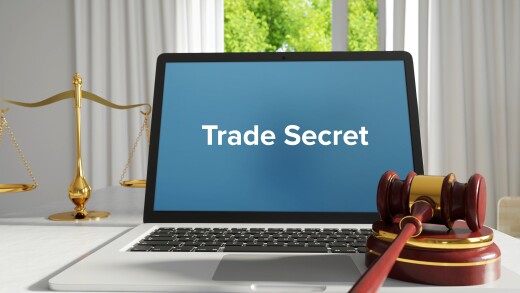 Trade Secret – Law, Judgment, Web. Laptop in the office with term on the screen. Hammer, Libra, Lawyer.