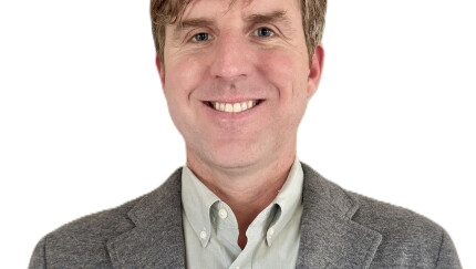 A man smiling for a portrait photo.