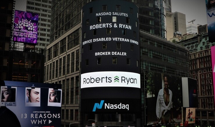 A sign highlighting disabled military veteran-owned firm Roberts & Ryan is displayed in Times Square.